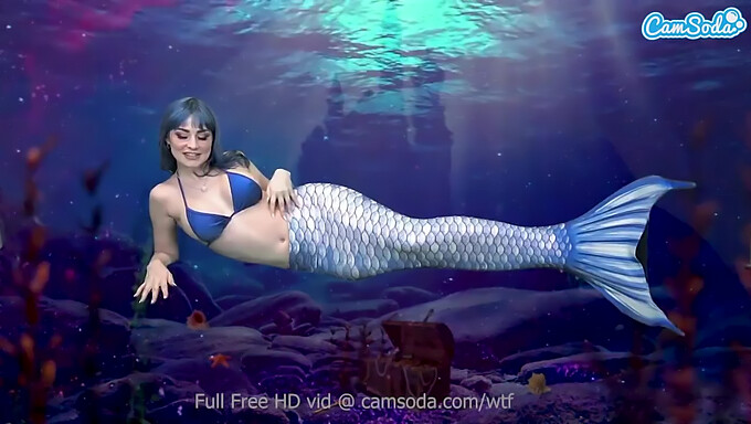 Uma camgirl sedutora em cosplay de sereia se satisfaz com uma excitação intensa